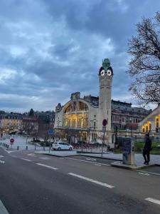a building with a clock tower in front of a building at L'Eden Rouennais - Gare de Rouen in Rouen
