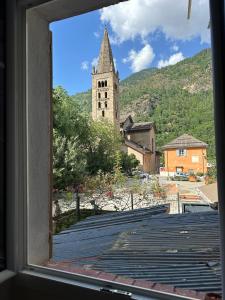 een raam met uitzicht op een kerk bij Studio Le Clocher in Saint-Étienne-de-Tinée