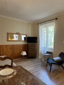 een woonkamer met een tafel en een televisie bij Studio Le Clocher in Saint-Étienne-de-Tinée