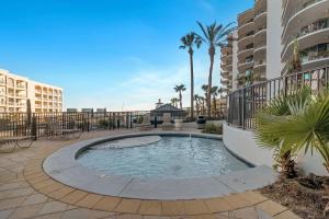 une piscine dans un patio avec des palmiers et des bâtiments dans l'établissement Lighthouse on the Bay Unit 2411, à Caswell