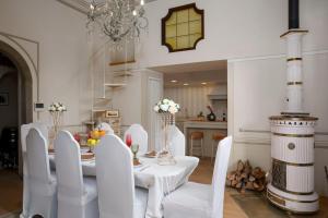 Un comedor con una mesa blanca y sillas blancas. en Villa Ridente - Elegance and views of Florence, en Settignano