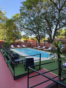 una piscina con sillas y una mesa en Terra Iguazú Suites, en Puerto Iguazú