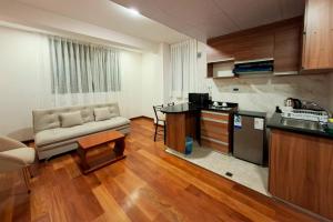 a living room with a couch and a kitchen at Sarawi Inn in La Paz