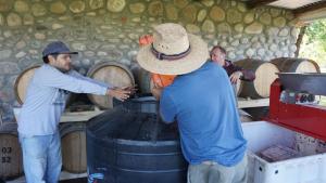 a group of men standing around a barrel at Cabañas La Sarita in La Consulta