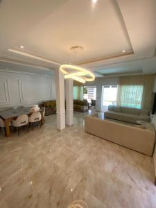 un grand salon avec un canapé et une table dans l'établissement Villa H modern living steps from the beach, à Temara