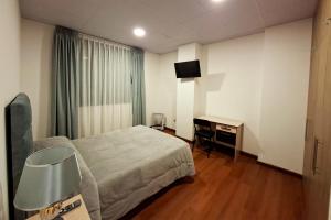 a hotel room with a bed and a desk at Sarawi Inn in La Paz