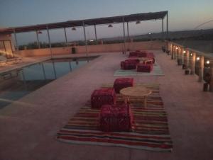 a row of chairs and tables on top of a building at ITRANE Agafay in Marrakesh +42 photos