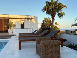 a group of chairs sitting on a patio next to a swimming pool at Villa Claus in Puerto Calero