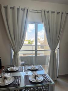 a dining room table with plates of food and a window at (208)Apt de luxo com varanda 2 quartos 1km do Mar in Tambauzinho +37 photos