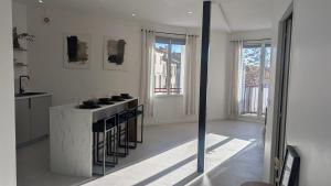 a white kitchen with a stove and a counter top at L'alcôve - appartement moderne et spacieux - proche gare - centre historique - WiFi - Clim in Béziers