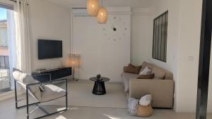 a living room with a couch and a tv at L'alcôve - appartement moderne et spacieux - proche gare - centre historique - WiFi - Clim in Béziers