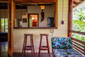 a porch with two stools and a mirror at Bluff Beach Retreat in Bocas del Toro