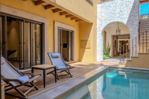 サンミゲル・デ・アジェンデにあるDesigner Retreat in Centro Heated Pool & Viewsのパティオ(椅子2脚付)、スイミングプールが備わります。