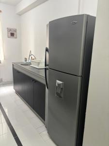 a stainless steel refrigerator in a kitchen with a counter at Comfortable apartment in South Quito in Quito +5 photos