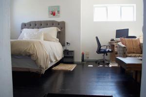 Un dormitorio con una cama, un escritorio y una silla. en Serene escape in Johannesburg, en Fourways