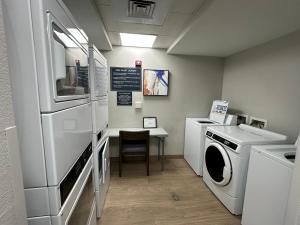 a laundry room with a refrigerator and a washer and dryer at Candlewood Suites Conway by IHG in Conway