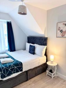 a bedroom with a bed with a blue headboard at Modern Flat Near Dover Castle in Dover