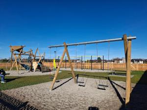 een speeltuin met schommels en glijbanen in een park bij Ferienwohnung Sternschnuppe in Chieming