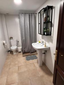 a bathroom with a toilet and a sink and a shower at Piso de 2 habitaciones en Arrecife in Arrecife