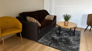 una sala de estar con un sofá y una mesa en Domaine Blue Garden, en Grandvillers