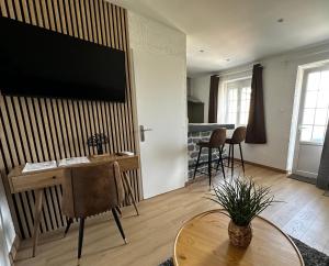 sala de estar con TV grande en la pared en Domaine Blue Garden, en Grandvillers