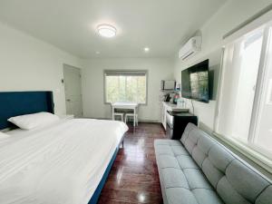 Temple Cityにある华人区花园别墅のベッドとソファと机のある寝室