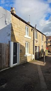 a brick house with a door on the side of it at Poppy Cottage in Matlock