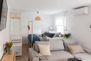 a living room with a couch in front of a bed at Charming Madrid lofts in Madrid