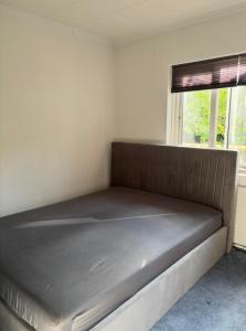 a bed in a small room with a window at Spacious & Cozy home with open kitchen lounge in Søborg