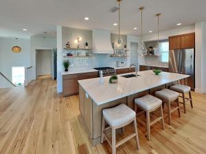 セント・オーガスティーン・ビーチにあるOcean Breezeのバースツール付きの大きな島のあるキッチンが備わります。 +44枚の写真