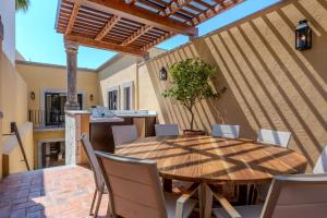 サンミゲル・デ・アジェンデにあるDesigner Retreat in Centro Heated Pool & Viewsの木製テーブルと椅子付きのパティオ