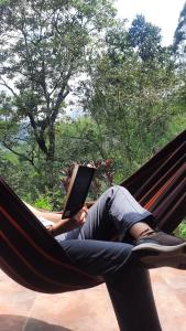 a person laying in a hammock with a book at Aire Libre Descanso in San Francisco