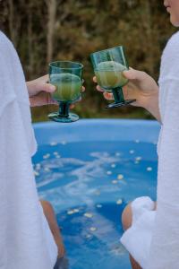 two people holding drinks in their hands near a swimming pool at Zen Sasino in Sasino