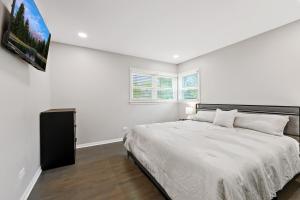 a white bedroom with a bed and a tv at Exceptional Willowbrook Retreat in Willowbrook