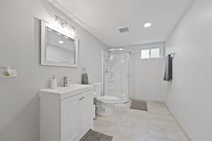 a white bathroom with a toilet and a shower at Exceptional Willowbrook Retreat in Willowbrook +19 photos