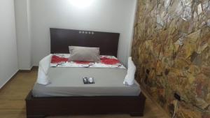 a bed in a room next to a stone wall at hotel salome in Puerto Triunfo