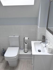 a white bathroom with a toilet and a sink at Castle-View Apartment & Free Parking on Site in Dover +12 photos