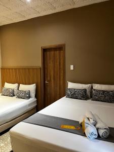 two beds sitting next to each other in a room at Casa Roman Hotel Boutique in Cartagena de Indias