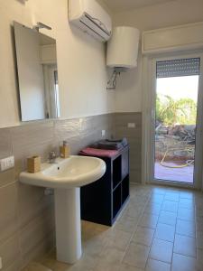 een badkamer met een wastafel en een spiegel bij La Casa dell'Aviatore in Boccadifalco +25 foto's