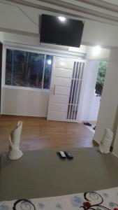 a living room with a tv and two remote controls at hotel salome in Puerto Triunfo