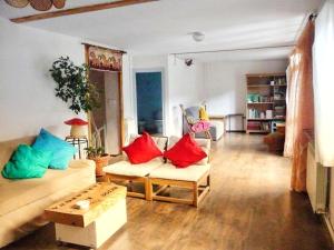 a living room with red and blue pillows on a couch at Casa La Farrapona de Babia in Torrestío