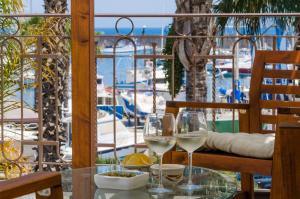 a table with two glasses of white wine on a balcony at Casa delle Zammare Fronte mare centro storico in Riposto