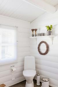 une salle de bain blanche avec toilettes et fenêtre dans l'établissement Hear The Sea From Log Cabin In Gilleleje, à Gilleleje 27 autres photos