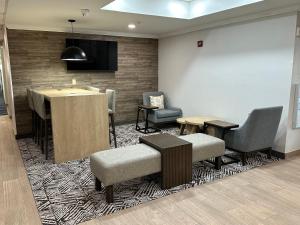 a waiting room with chairs and a table and a bar at Candlewood Suites Conway by IHG in Conway