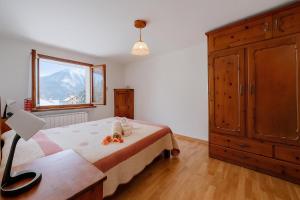 a bedroom with a bed with a dresser and a window at Miramonti 21 Ski In - Ski Out - Happy Rentals in Sauze dʼOulx