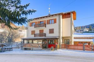 a building with a red door in the snow at Miramonti 21 Ski In - Ski Out - Happy Rentals in Sauze dʼOulx