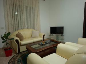 a living room with two couches and a tv at Guest house Irvin in Berat