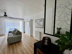 een woonkamer met een bank en een stoel bij L'Echappée REmily - La Rochelle - proche Ile de Ré in La Rochelle