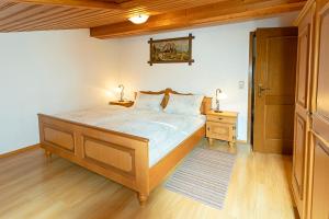 een slaapkamer met een groot bed en 2 lampen op een tafel bij Bauernhof Daurerhof Ferienwohnung in Aschau im Chiemgau