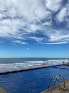a swimming pool next to a beach with the ocean at Marina del Sol Resort Condo directly on the Ocean 102 in Mazatlán